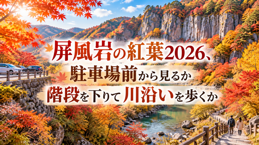 赤や橙に色づく屏風岩と渓谷を望み、川沿いの散策路を秋の装いの人が歩く紅葉風景